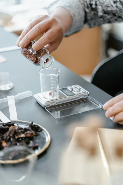 a person sitting at a table with a plate of food, alchemist lab, taking tobacco snuff, made of high tech materials, botanicals