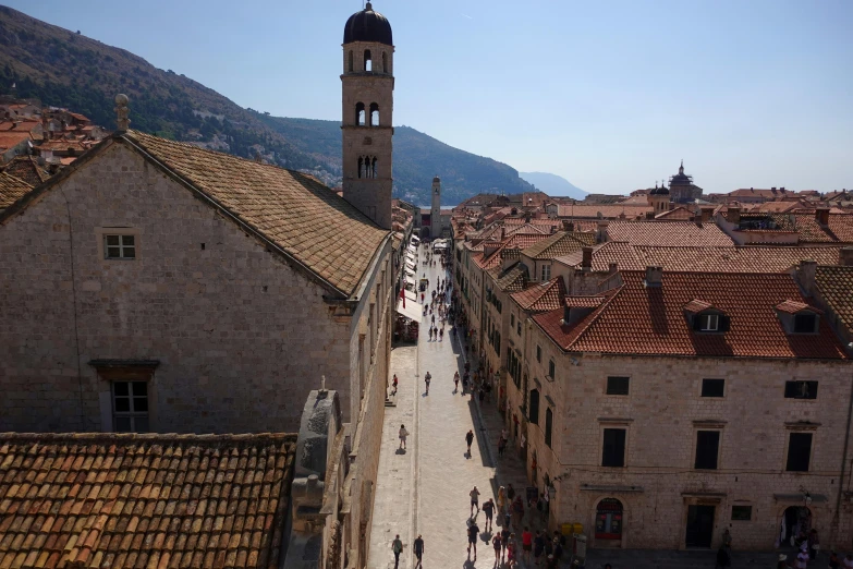 a group of people walking down a street next to tall buildings, a picture, renaissance, dubrovnik, avatar image, high view, square