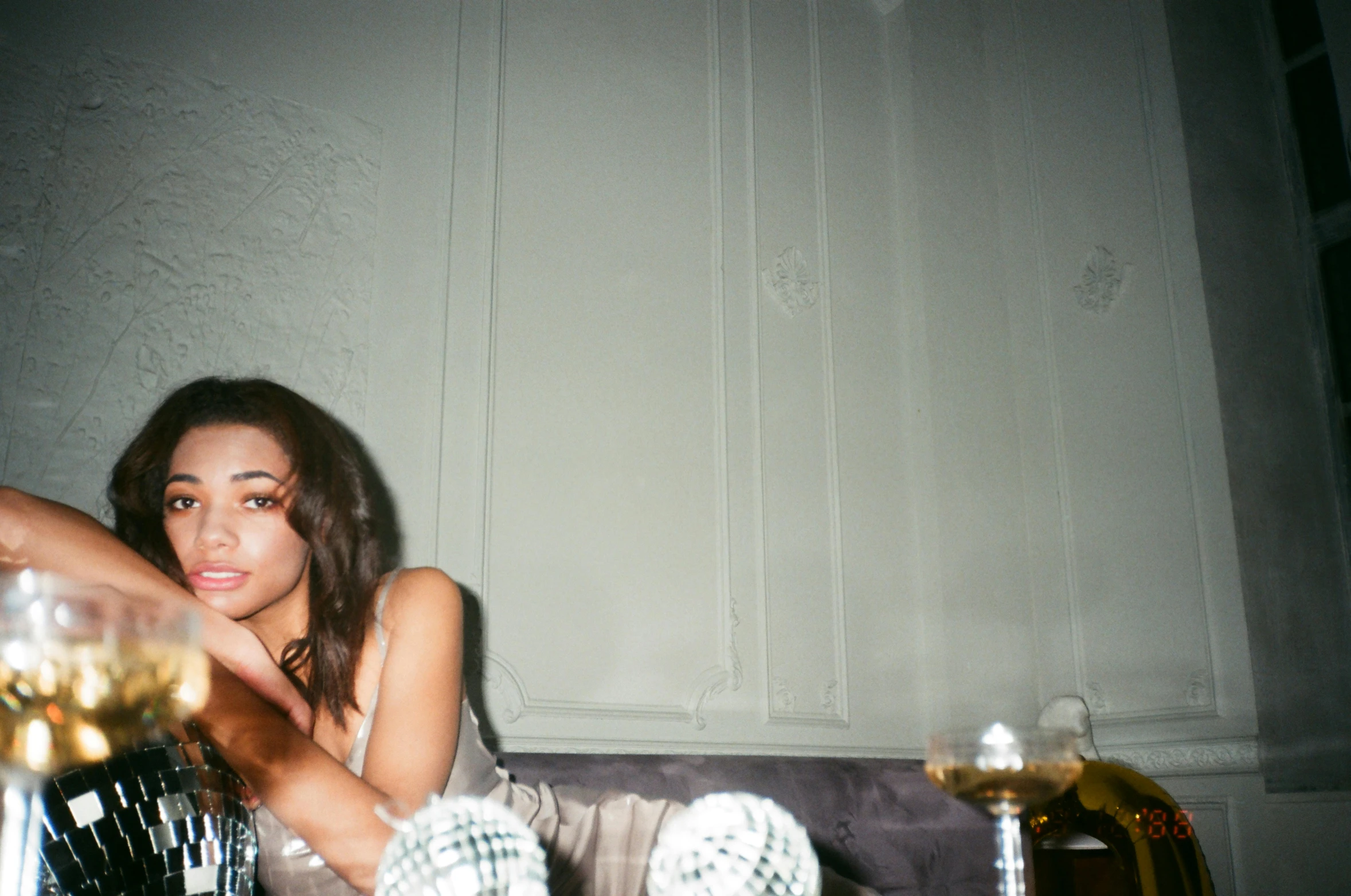 a woman sitting on a couch with a glass of wine, a polaroid photo, inspired by Elsa Bleda, trending on pexels, arabesque, shanina shaik as medusa, very smoky paris bar, f 1.4 kodak portra, nightlife