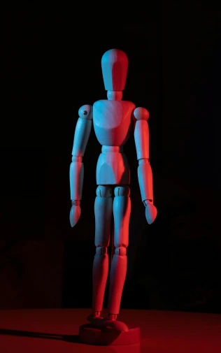 a wooden mannequin sitting on top of a table, by David Donaldson, pexels, red and blue black light, articulated joints, standing alone, < full body robot >
