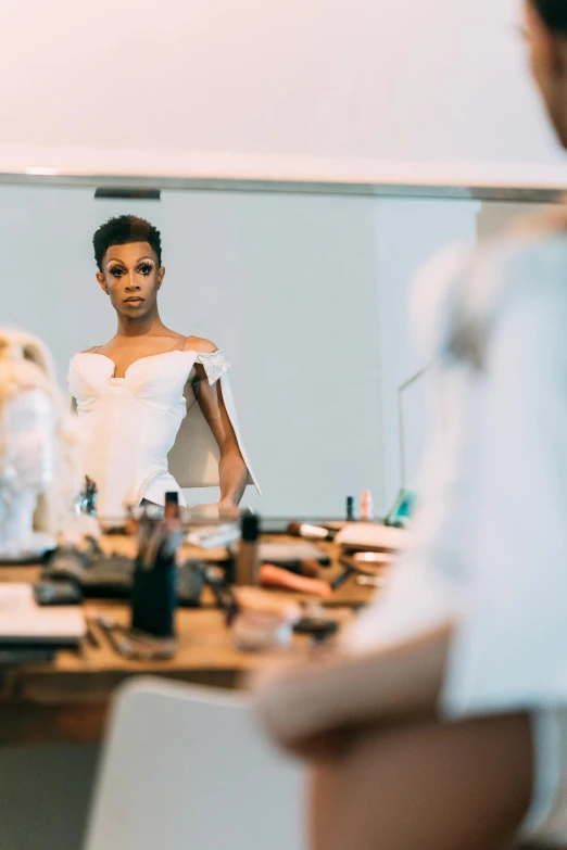 a woman that is standing in front of a mirror, on a white table, ashteroth, wearing a wedding dress, production photo