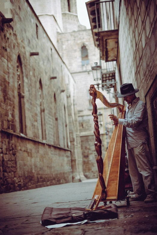 a man playing a musical instrument in an alley, pexels contest winner, baroque, in barcelona, 🚿🗝📝, profile image, with an harp