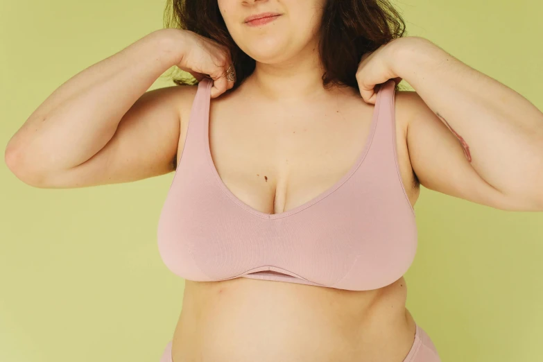 a woman in a pink bra top posing for a picture, by Carey Morris, trending on pexels, plasticien, eucalyptus, slightly overweight, detailed product image, thick lining