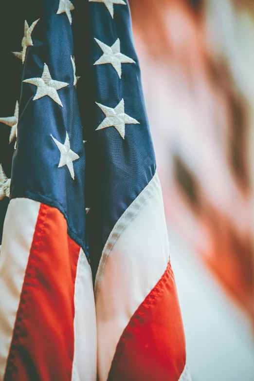 an american flag hanging from the side of a building, up-close, profile image, american flags, 🚿🗝📝