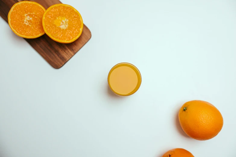 oranges and a glass of orange juice on a cutting board, trending on pexels, background image, minimalistic aesthetics, thumbnail, taken with sony alpha 9