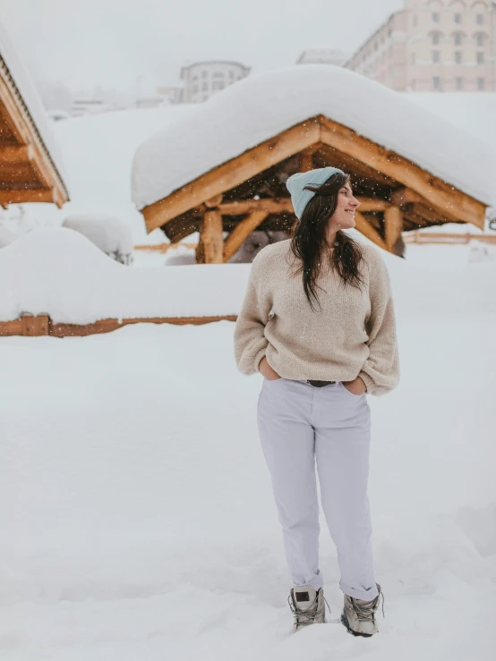 a woman standing in the snow in front of a lodge, pexels contest winner, white pants, designed for cozy aesthetics!, profile image, avatar image