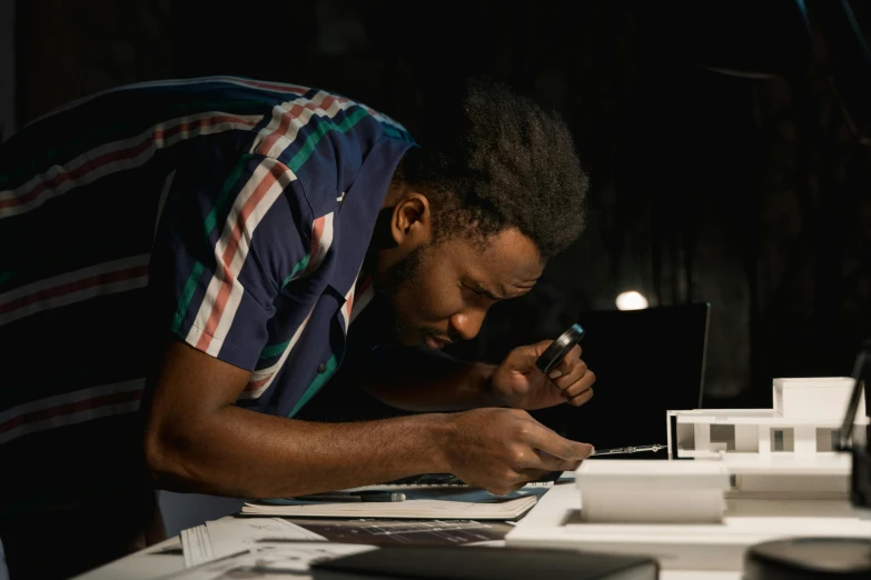 a man is looking through a magnifying glass, inspired by Afewerk Tekle, pexels contest winner, hyperrealism, working on a laptop at a desk, projection mapping, side profile shot, a high angle shot