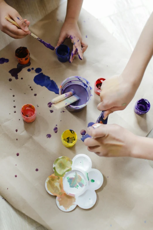 a group of people that are painting on a table, a child's drawing, trending on pexels, process art, paint drops, thumbnail, decoration, deep colour