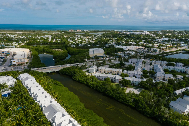 an aerial view of a city with a river running through it, by Carey Morris, pexels contest winner, mangrove trees, white houses, 4k panoramic, fan favorite