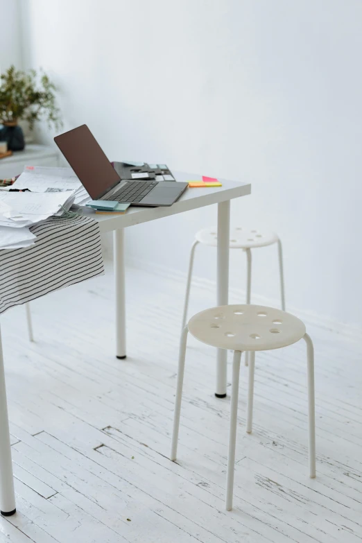 a table with a laptop sitting on top of it, by Alice Mason, unsplash, computer art, stools, cream and white color scheme, studio floor, dwell