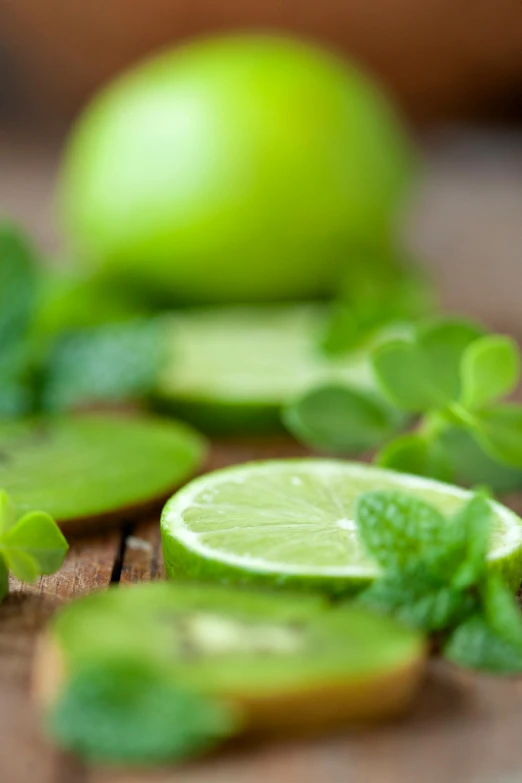 a wooden table topped with sliced limes and mint leaves, renaissance, apple, profile image, essence, greens