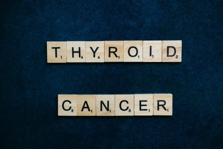 the word thyroid cancer spelled in scrabbles on a blue background, by Caroline Mytinger, on a dark background, multi-part, promotional image, archived photograph