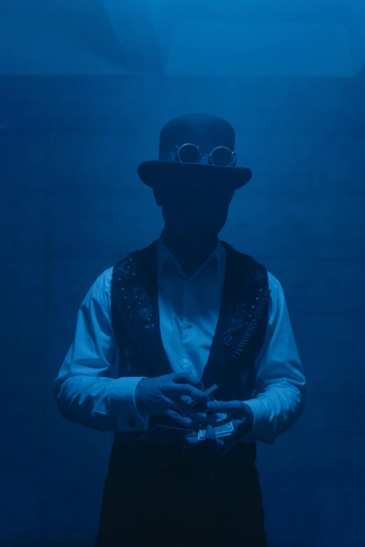 a man in a hat and vest holding a camera, inspired by Joseph Beuys, unsplash, surrealism, ethereal blue lighting, ( steampunk ), volumetric fog and lighting, ( ( theatrical ) )