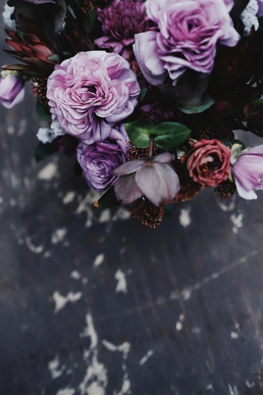 a bouquet of flowers sitting on top of a table, by Sara Saftleven, trending on unsplash, romanticism, dark purple scheme, delicate patterned, layered texture, pastel roses