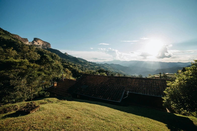 a house sitting on top of a lush green hillside, by Peter Churcher, unsplash contest winner, happening, golden hour sunlight, sri lankan landscape, wood cabin in distance, breakfast at las pozas