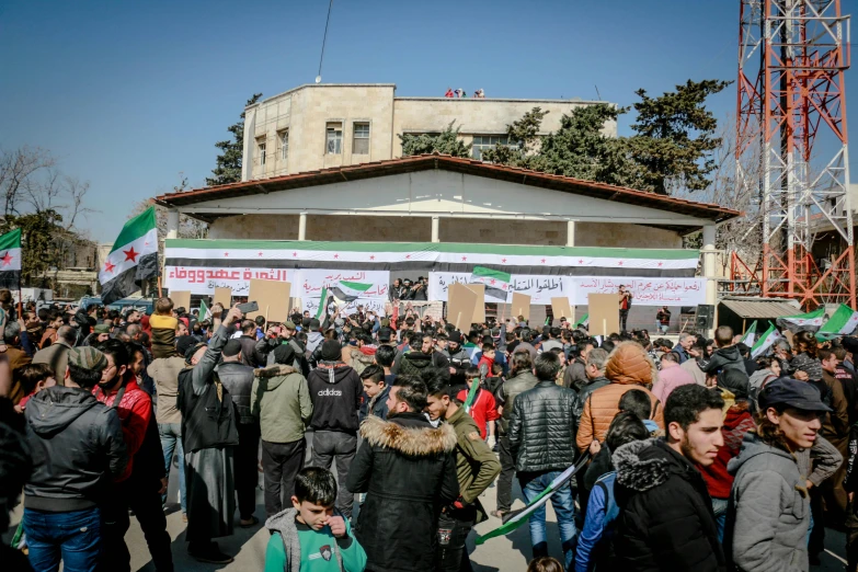 a large group of people standing in front of a building, by Abdullah Gërguri, flickr, protest, square, high quality photo, february)