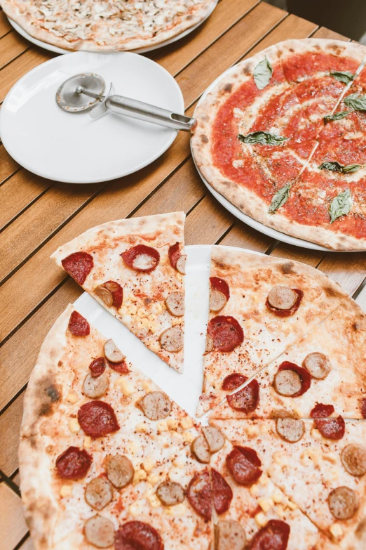 a couple of pizzas sitting on top of a wooden table, silver white red details, thumbnail, flatlay, 3 - piece