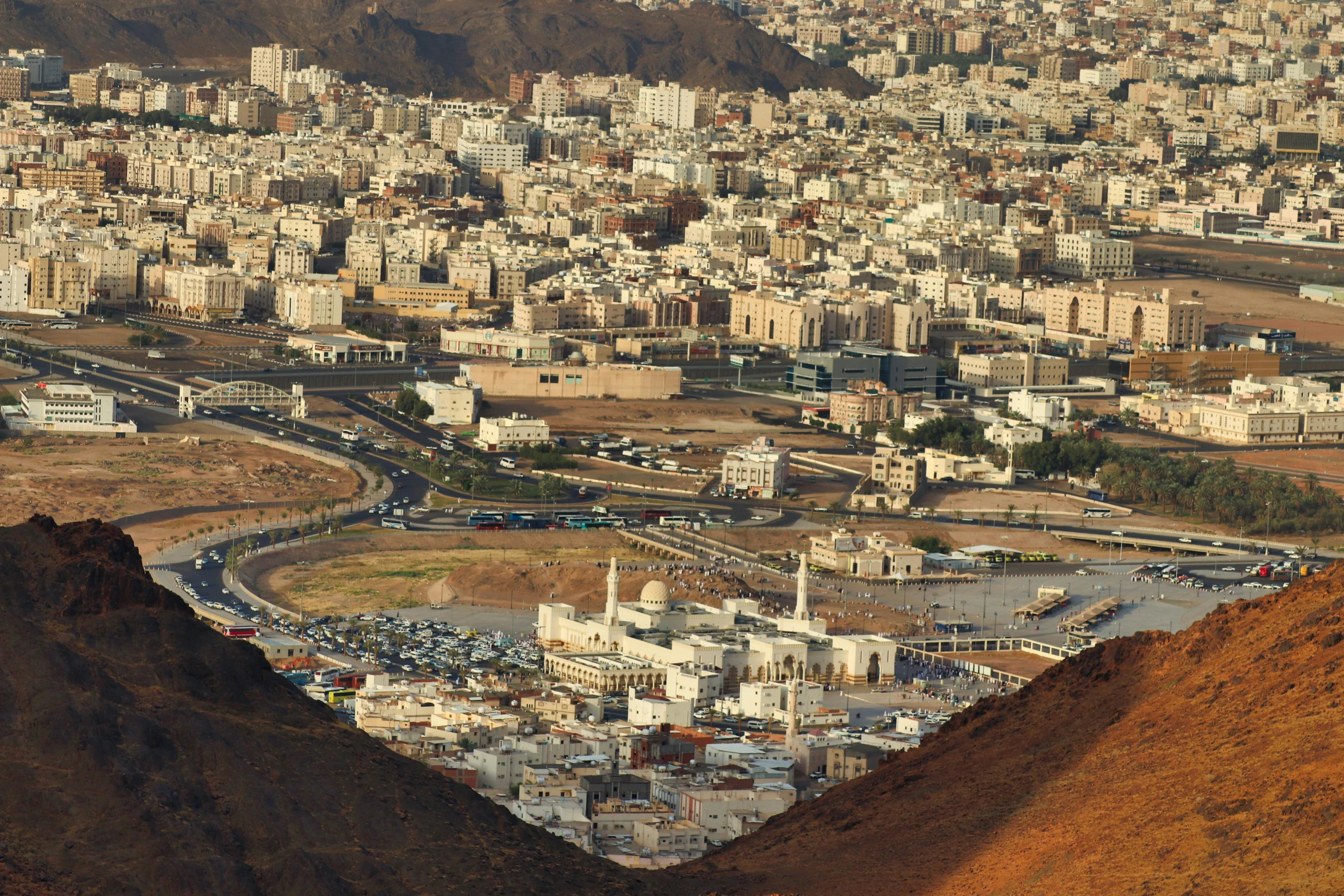 a view of a city from the top of a mountain, pexels contest winner, hurufiyya, oman, brown, 2000s photo, in the middle of the city