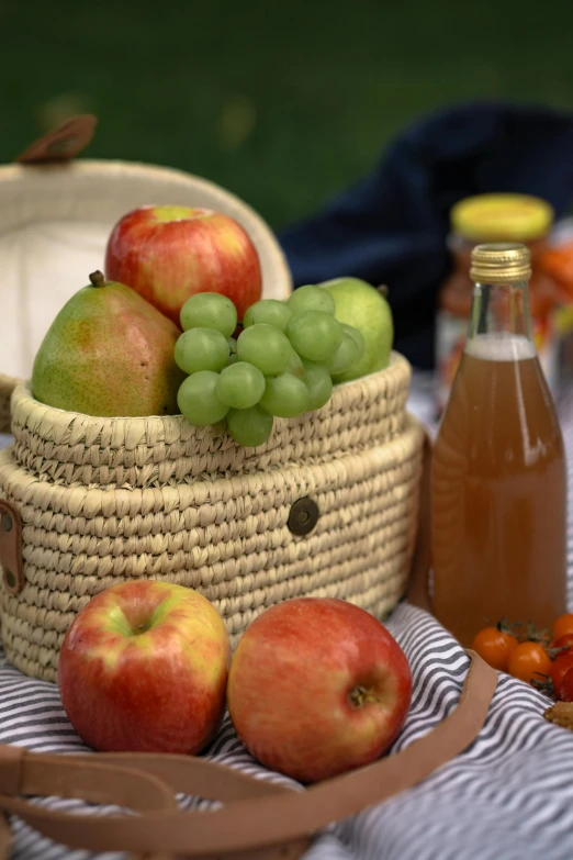 a basket of apples sitting on top of a table, people on a picnic, juice, up close, square