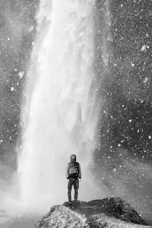 a man standing in front of a waterfall, a black and white photo, inspired by jessica rossier, process art, falling snow, lava!!!, fountain of water, portrait of tall
