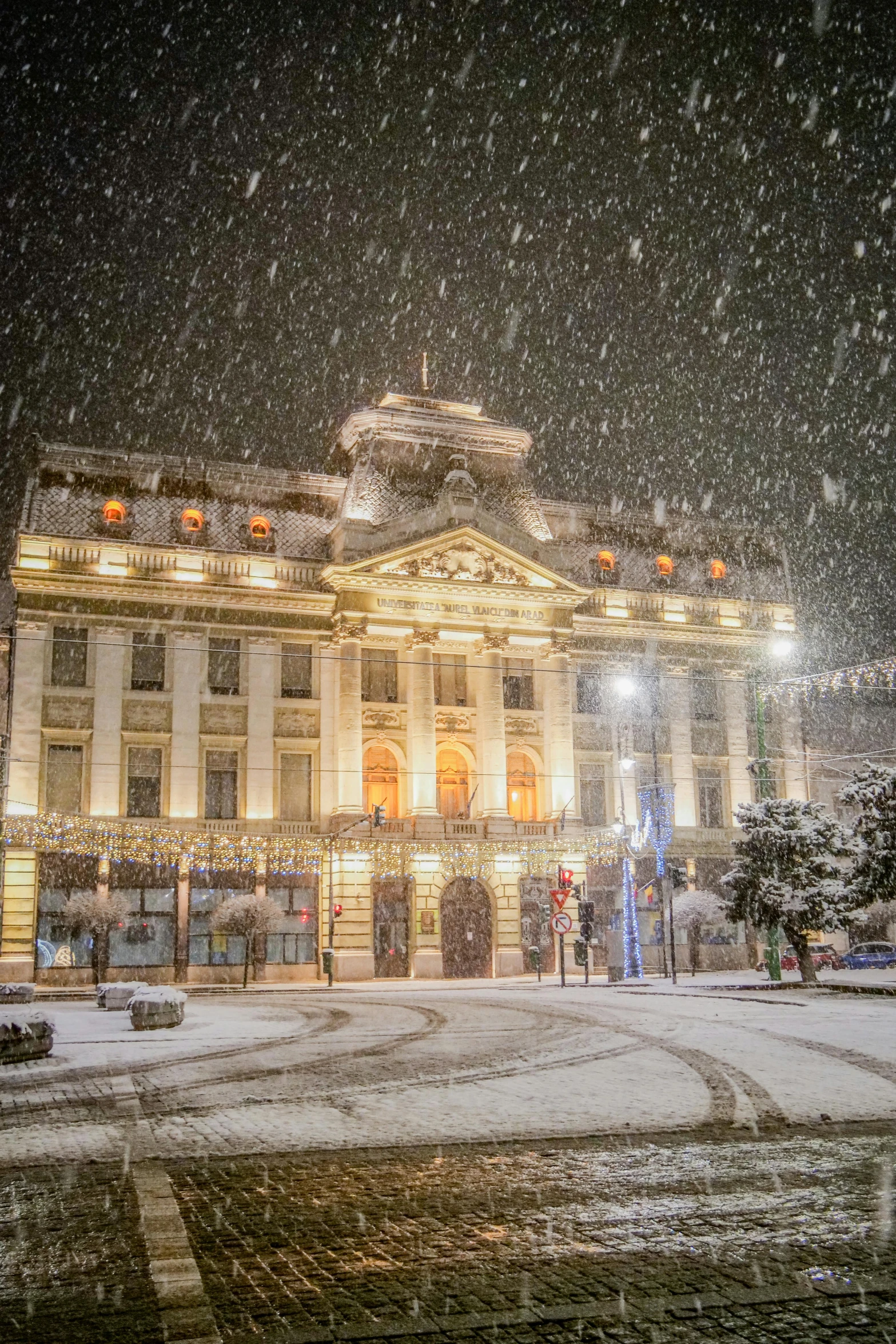 a large building covered in snow next to a street, renaissance, profile image, light show, prefecture streets, winter time