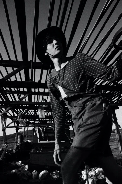 a black and white photo of a man on a skateboard, inspired by Ueda Fumito, wears a destroyed hat, jonny greenwood, stood in a factory, issey miyake