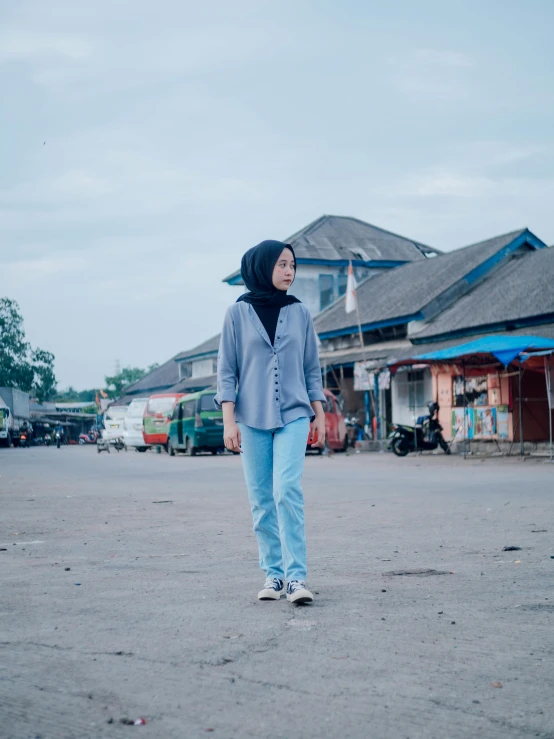 a woman standing in the middle of a street, a picture, by Abidin Dino, unsplash, realism, blue and grey theme, wearing farm clothes, 😃😀😄☺🙃😉😗, casual clothing style