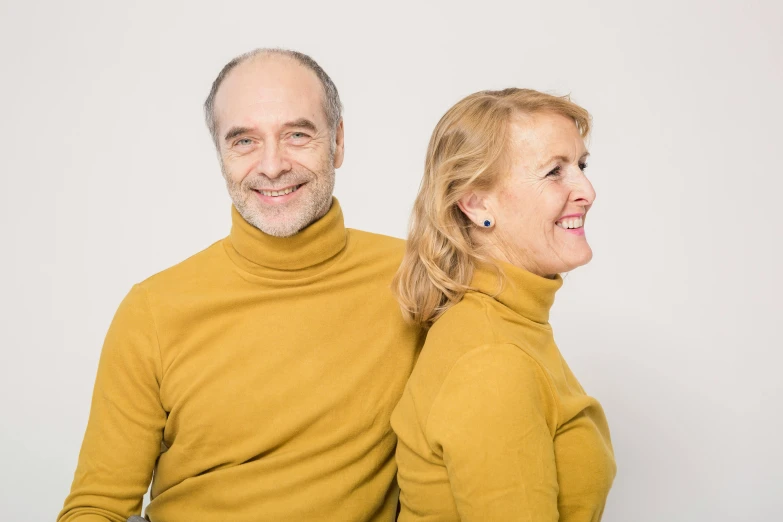 a man and a woman standing next to each other, yellows, mature content, portrait image, plain background