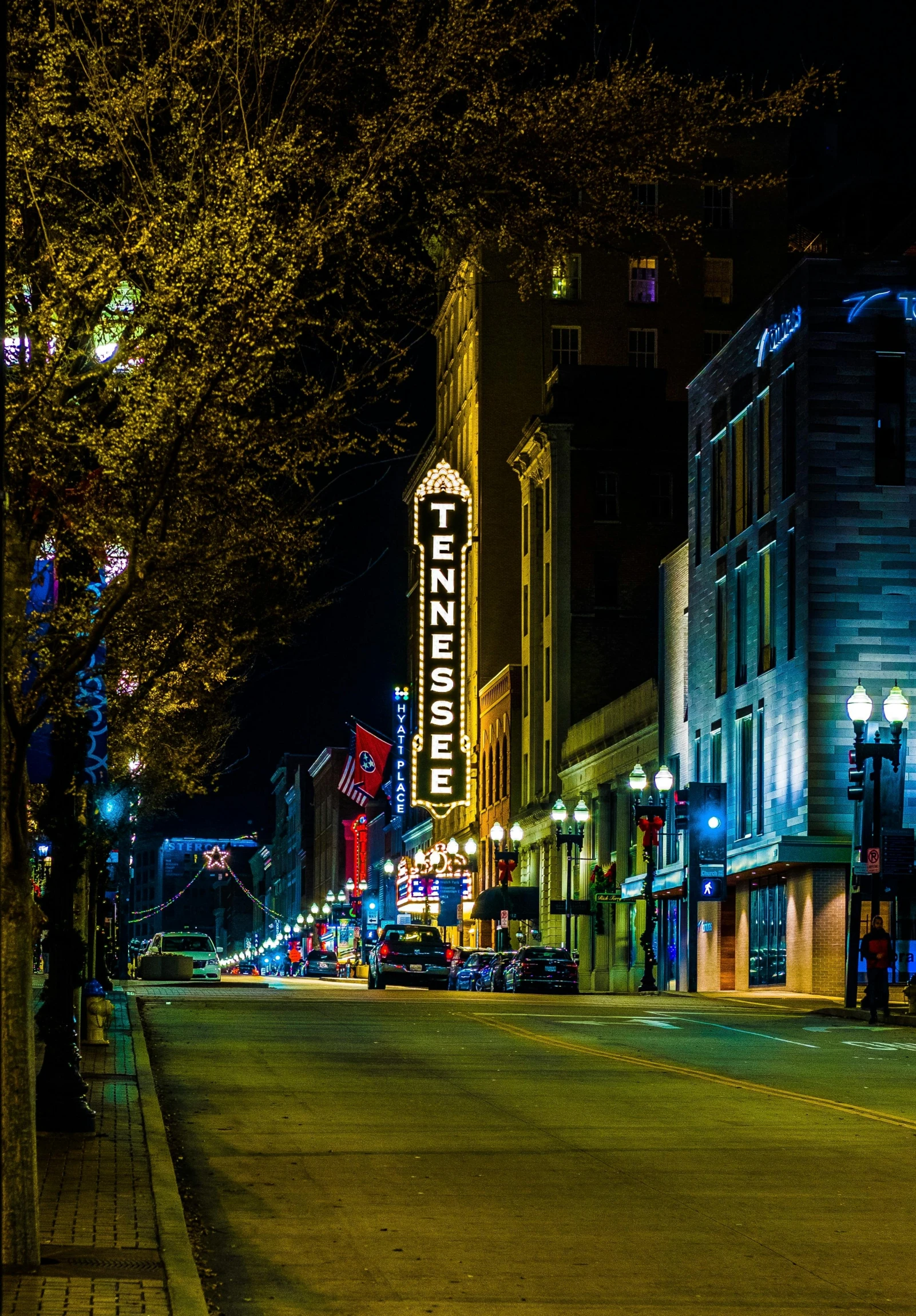 a city street lined with tall buildings at night, renaissance, tn, square, highlight, iu