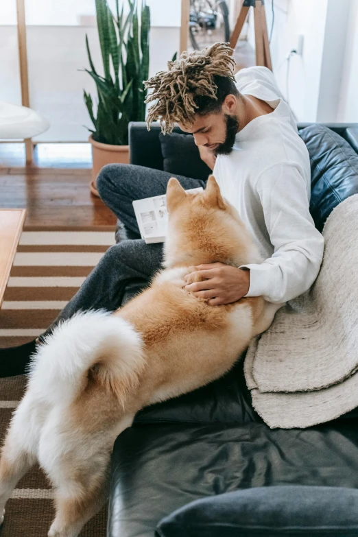 a man sitting on a couch with a dog, thick fluffy tail, holding each other, millennial vibes, gif
