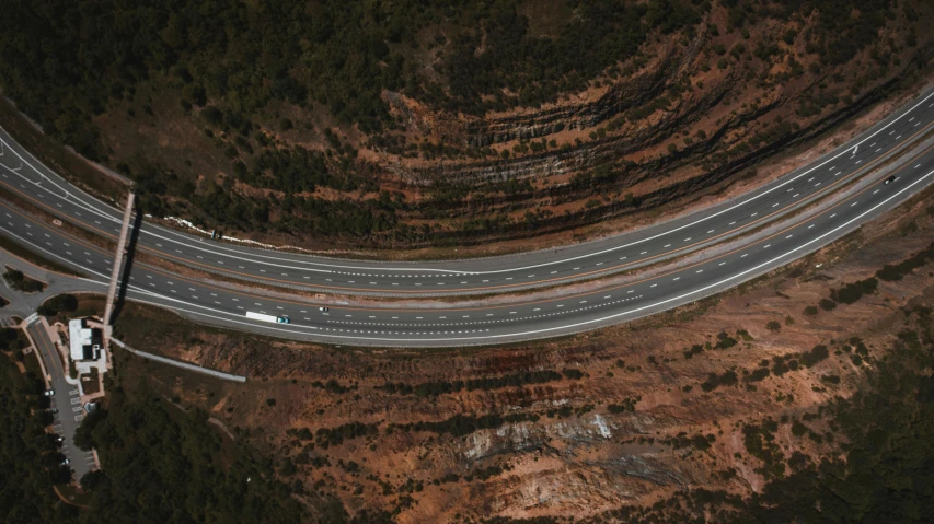an aerial view of a highway with multiple lanes, by Lee Loughridge, unsplash contest winner, photorealism, over a cliff, lachlan bailey, thumbnail, vehicle