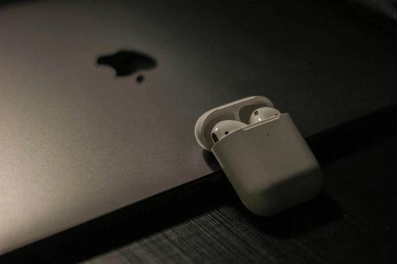 a close up of an apple airpods next to a laptop, pexels, white on black, square, worthless, drone footage