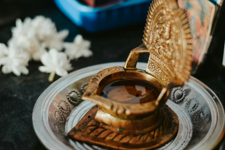 a close up of a plate of food on a table, a bronze sculpture, hurufiyya, hindu aesthetic, maple syrup, brass, thumbnail