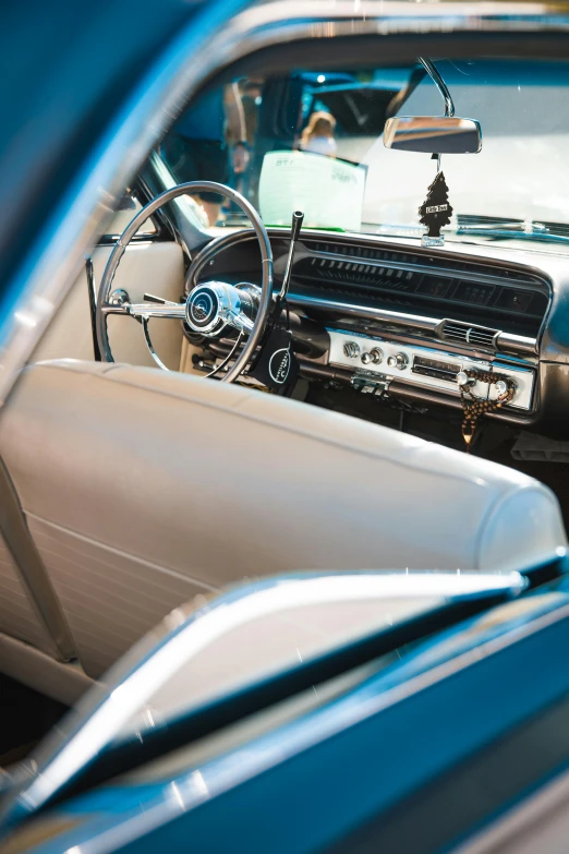a view of the interior of a classic car, pexels contest winner, modernism, white and teal metallic accents, concert, aftermarket parts, from the side