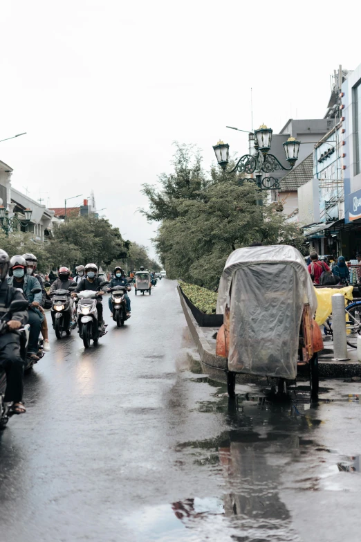 a group of people riding motorcycles down a street, by Basuki Abdullah, trending on unsplash, wet climate, square, van, on display