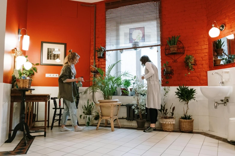 a couple of women standing next to each other in a bathroom, arbeitsrat für kunst, plants and patio, red and brown color scheme, doctors office, small hipster coffee shop