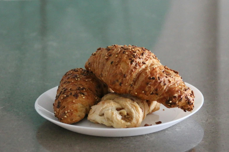 a close up of a plate of food on a table, breads, from the side, pastry lizard, 3 - piece