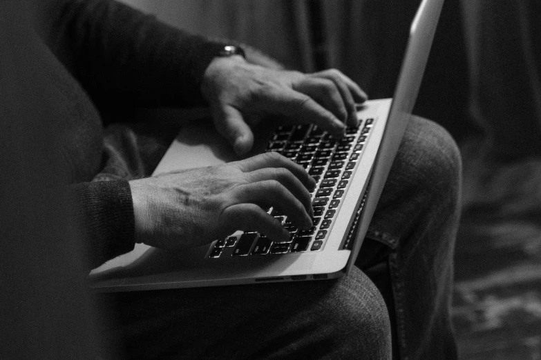 a close up of a person typing on a laptop, a black and white photo, man steal computers, by greg rutkowski, cozy, dsrl photo