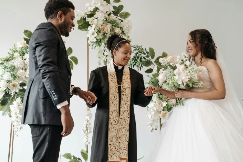 a man and a woman standing next to each other, by Carey Morris, trending on unsplash, renaissance, holy ceremony, ivory and ebony, floral couture, 3 - piece