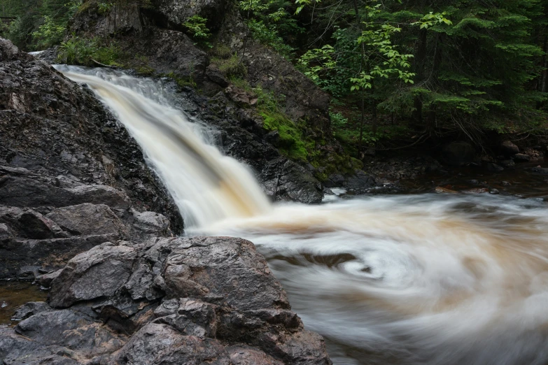 a large waterfall in the middle of a forest, by Jesper Knudsen, pexels contest winner, wet rocks, brown, white, panoramic shot