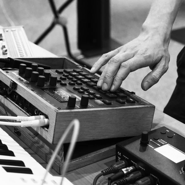 a close up of a person playing a musical instrument, inspired by John McLaughlin, synthetism, in a workshop, synthesizers, uploaded, autechre