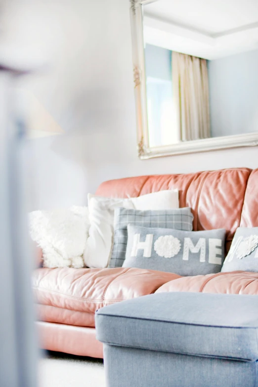 a couch sitting in a living room next to a mirror, a cross stitch, visual art, pastel blues and pinks, leather sofa, home display, silver red white details