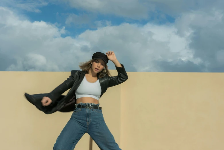 a woman jumping in the air on a skateboard, trending on pexels, leather jacket and denim vest, dua lipa, standing on a rooftop, classic dancer striking a pose