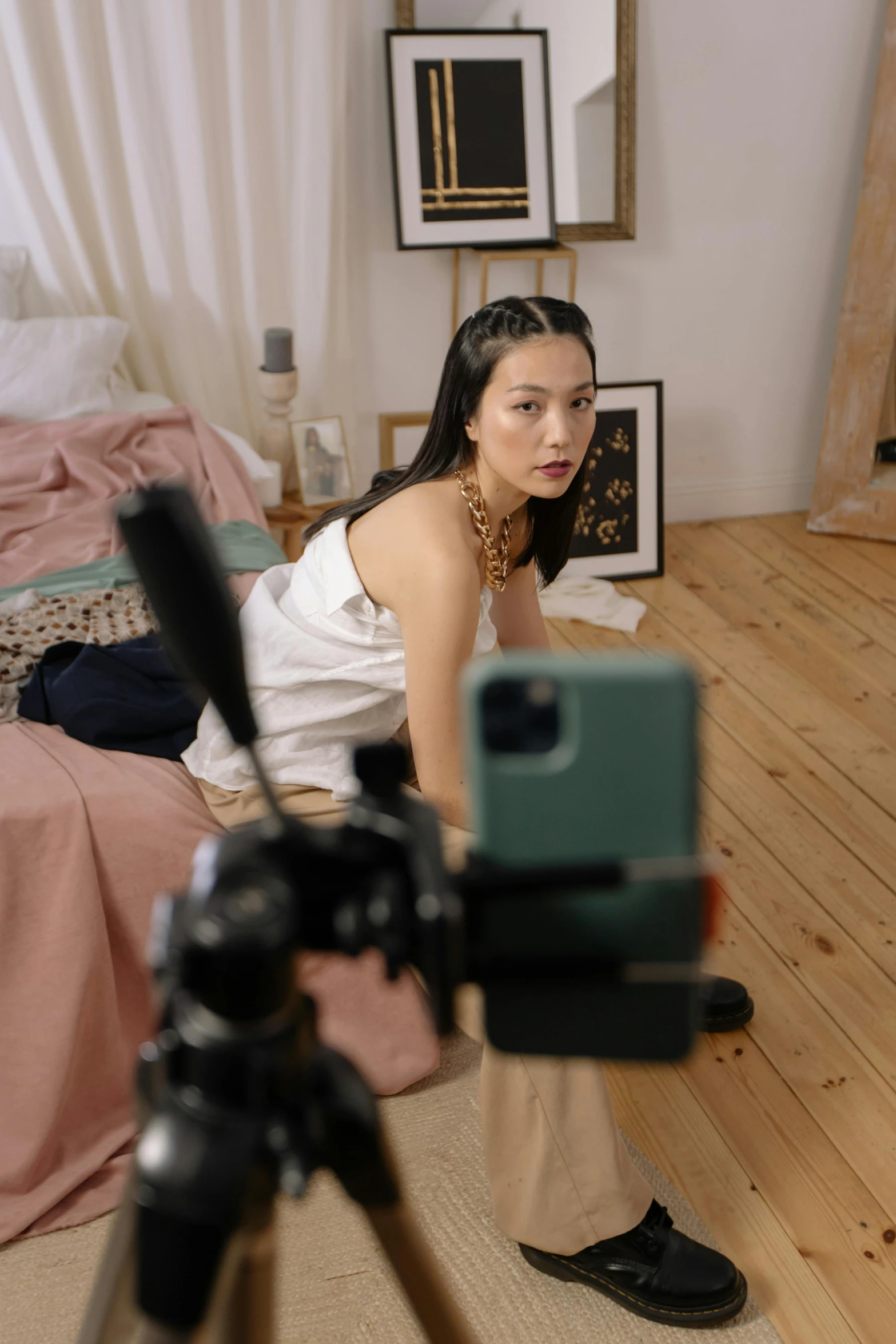 a woman sitting on the floor in front of a camera, inspired by Li Di, trending on pexels, half asian, iphone video, in a bedroom, movie setup