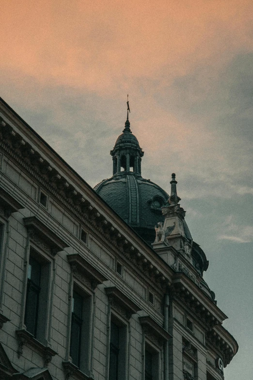 a clock that is on the side of a building, a photo, by Adam Marczyński, pexels contest winner, baroque, neoclassical tower with dome, dusk sky, low quality grainy, view from bottom