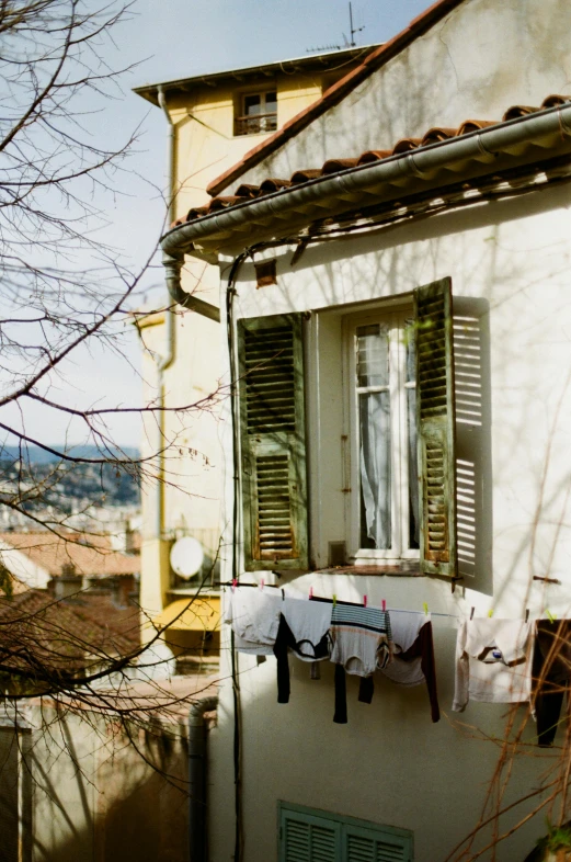 a house with clothes hanging out to dry, a photo, inspired by Albert Dorne, nice view, early spring, shutters, analogue photo low quality