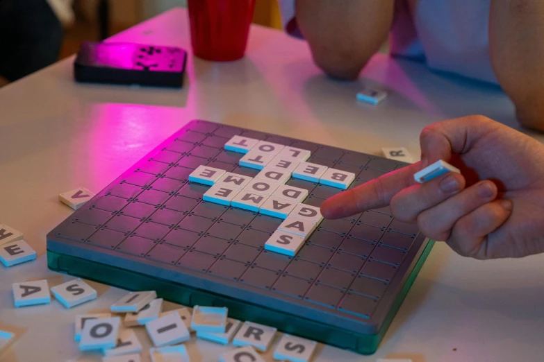 a person playing a game of scrabble on a table, private press, glowing digital runes, grey, set pieces, 2070