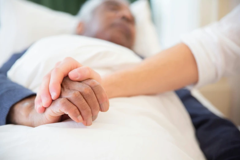 a man laying in a bed holding a woman's hand, health supporter, multiple stories, old man, unedited