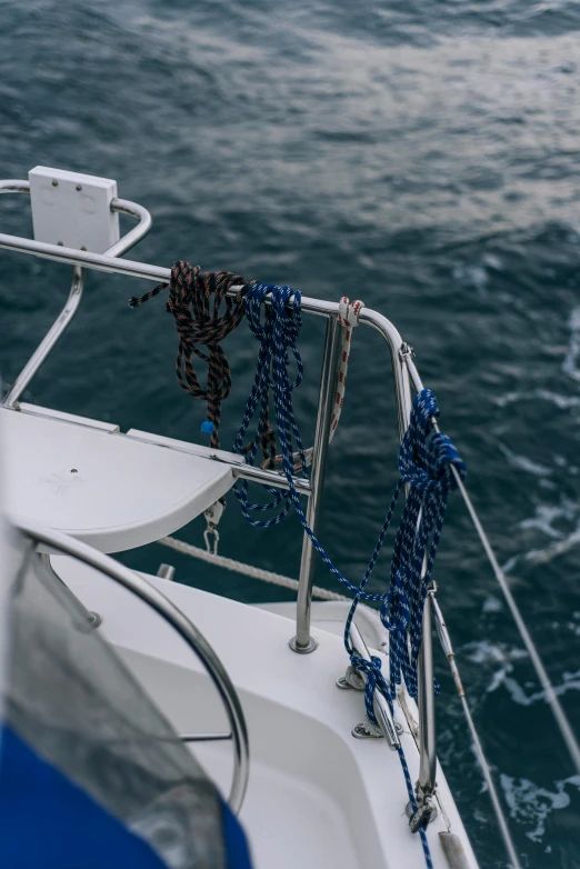 a close up of a boat on a body of water, ropes, blue water, the ocean