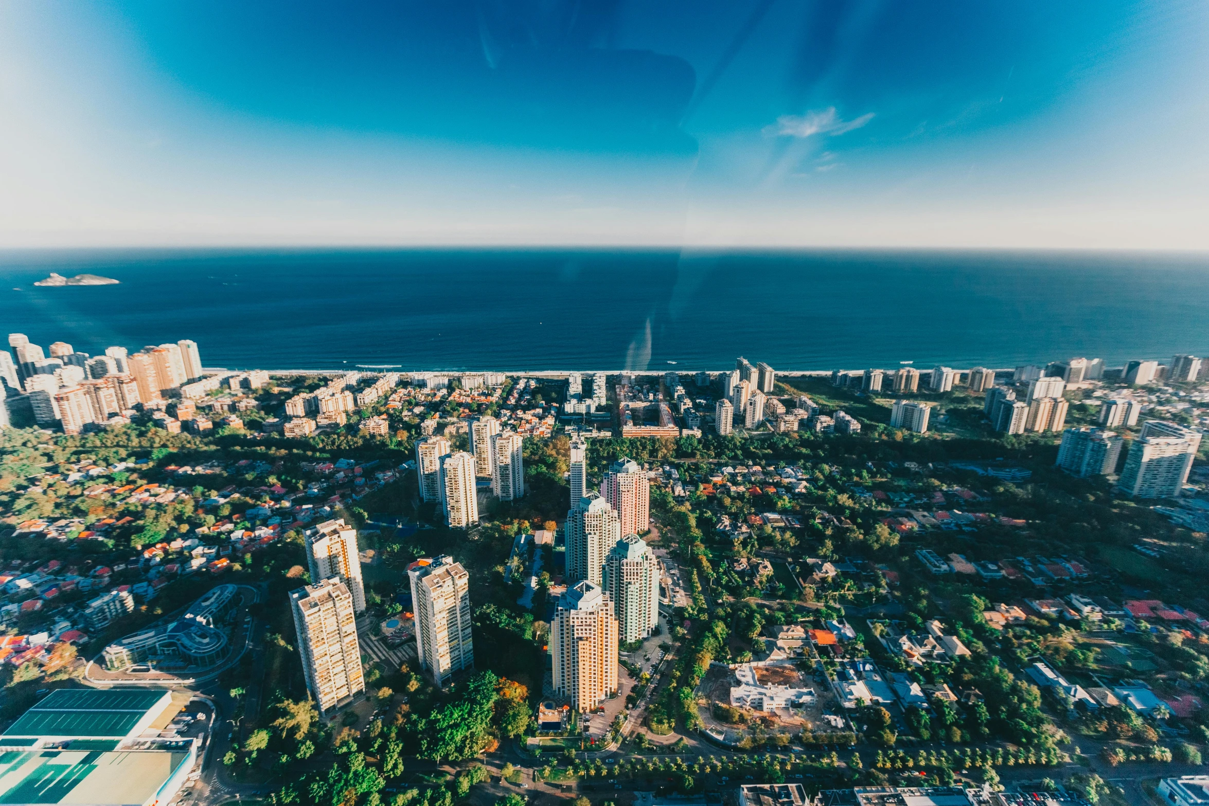 an aerial view of a city and the ocean, views to the ocean, blue skies, lachlan bailey, buenos aires